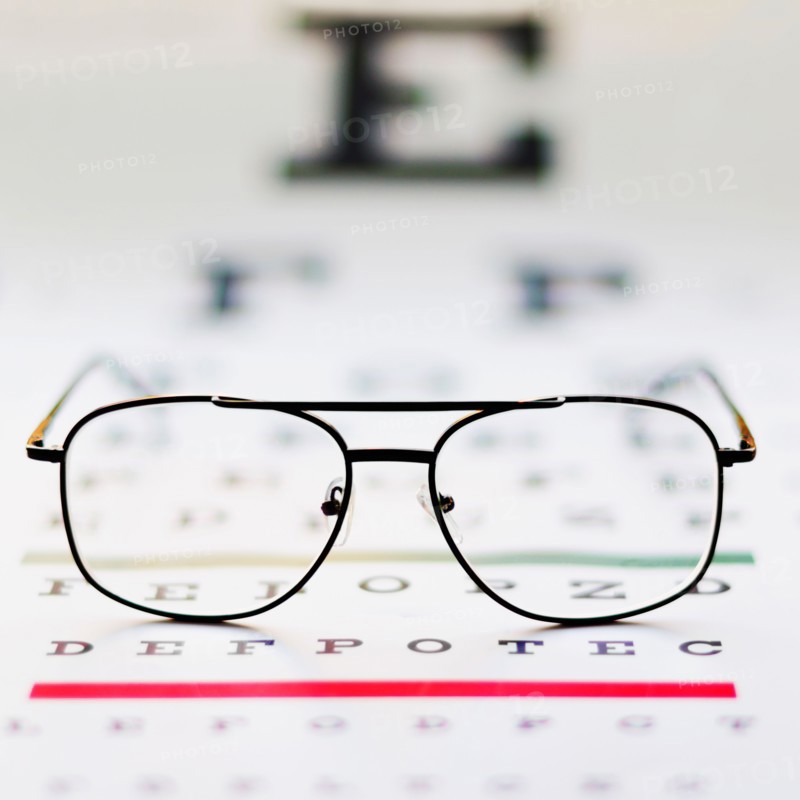 Close up of glasses on eye chart, studio shot.