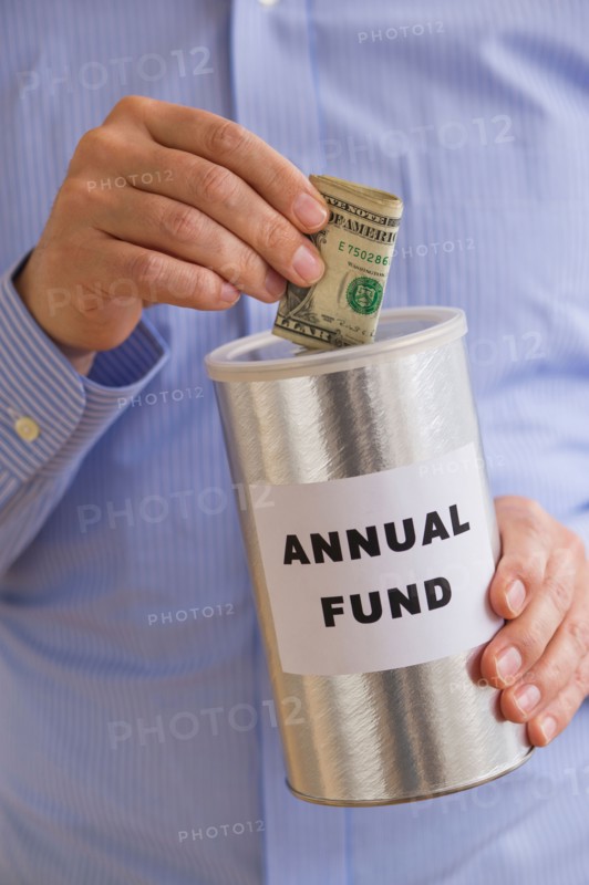 Man putting dollars into annual fund can.