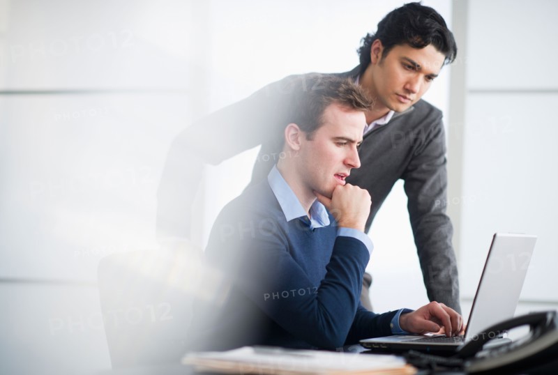 Two businessmen working with laptop.