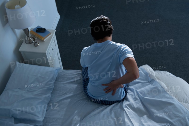 Man sitting on bed .