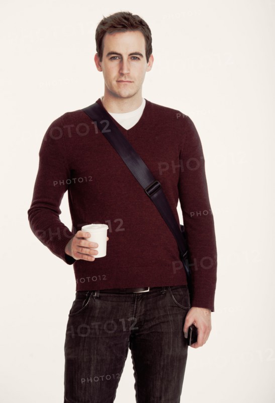 Studio shot of man holding coffee cup.