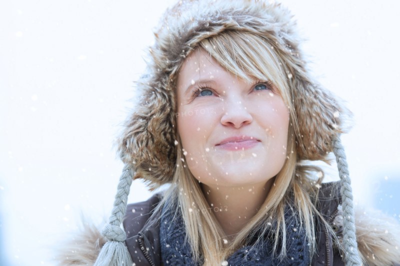 Portrait of woman wearing knit hat smiling.