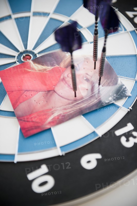 Photograph of woman stuck with darts. Photo : Jamie Grill