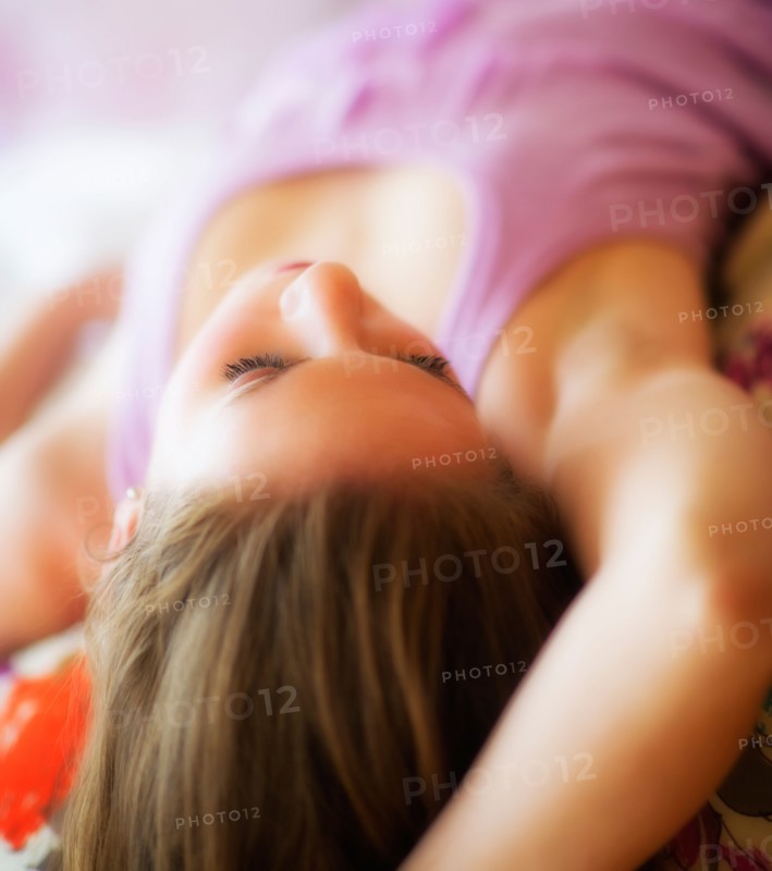 Young attractive woman lying on bed. Photo : Daniel Grill