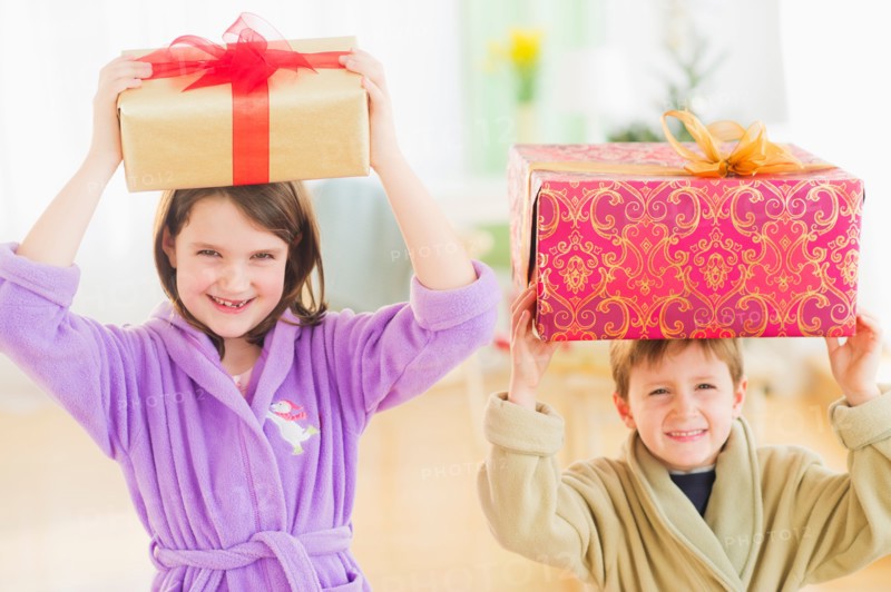 Girl (8-9) and boy (6-7) carrying christmas gifts on their heads. Photo : Daniel Grill