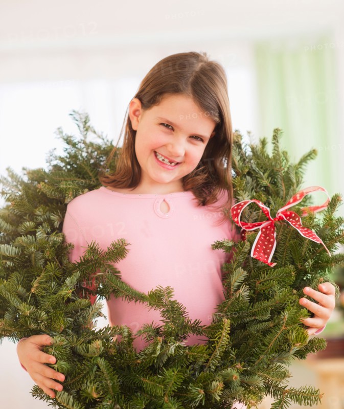 Portrait of girl (8-9) with christmas wreath. Photo : Daniel Grill