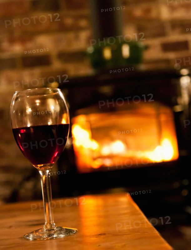 Wine glass with fireplace in background. Photo : Daniel Grill