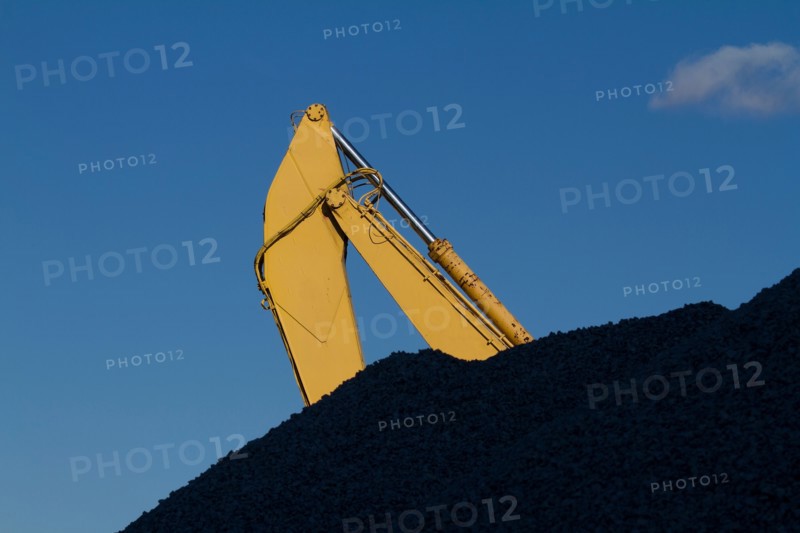 Part of crane behind coal stack. Photo : fotog