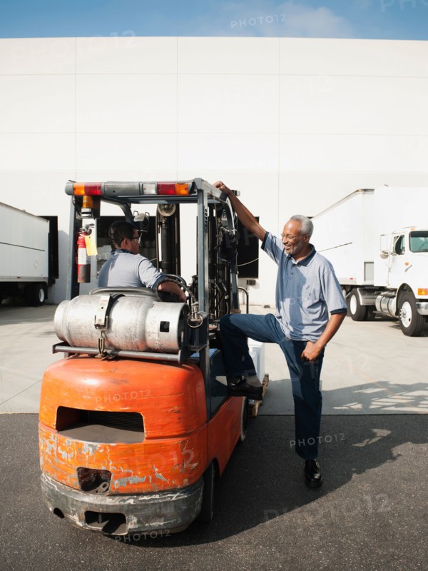 Two men working with forklift.