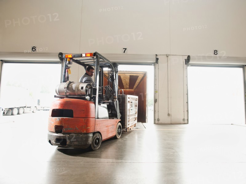Forklift driver working in warehouse.
