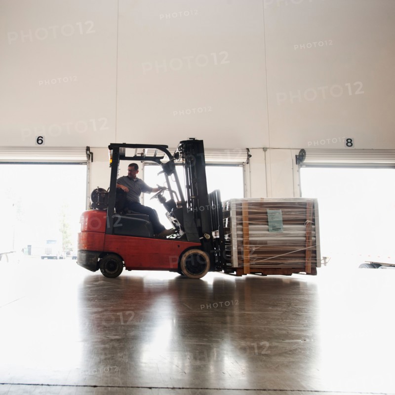 Forklift driver working in warehouse.