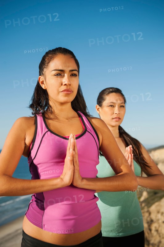 USA, California, San Diego, Two women practicing yoga on beach.