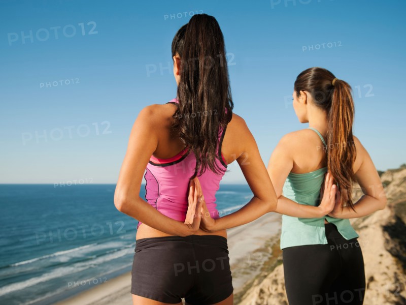 USA, California, San Diego, Two women practicing yoga on beach.