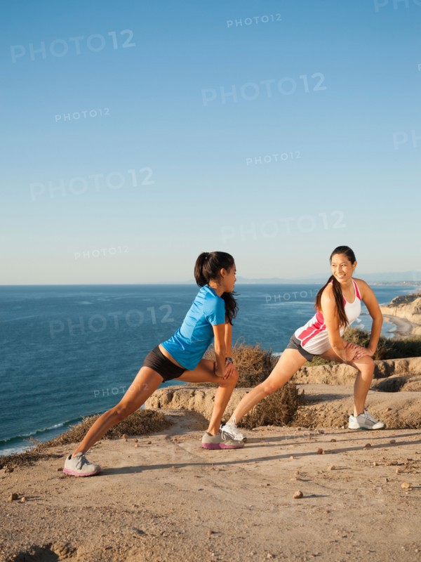 USA, California, San Diego, Two women stretching on beach.