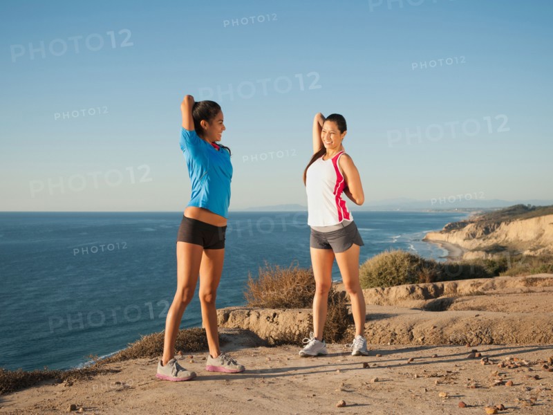 USA, California, San Diego, Two women stretching on beach.