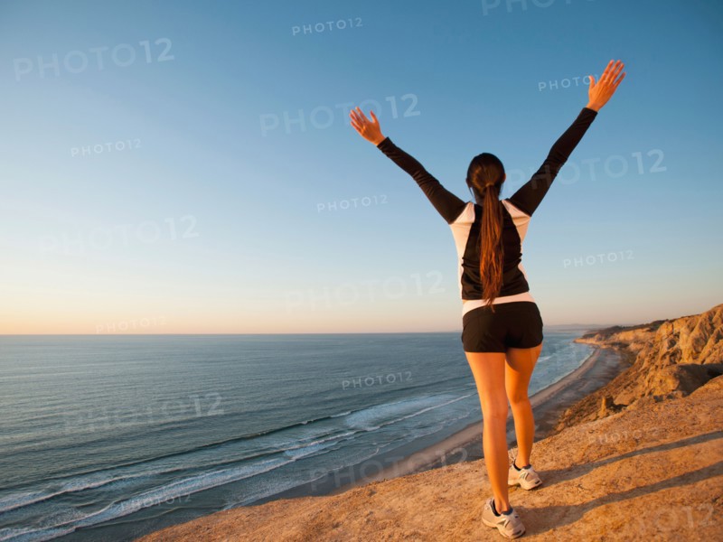 USA, California, San Diego, Woman stretching at beach.