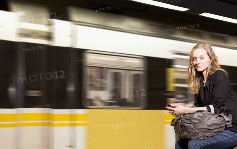 USA, California, Los Angeles, Woman sending text messages on subway station. Photo : Sarah M. Golonka