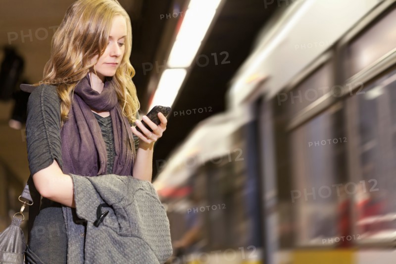 USA, California, Los Angeles, Woman sending text messages on subway station. Photo : Sarah M. Golonka