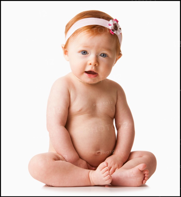 Portrait of baby girl (6-11 months) smiling, studio shot. Photo : Mike Kemp