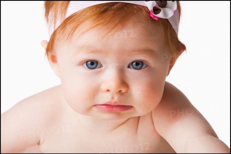 Portrait of baby girl (6-11 months) looking at camera, studio shot. Photo : Mike Kemp