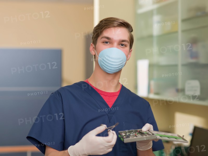 Portrait of dentist holding dental tools. Photo : Dan Bannister