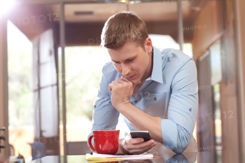 Man texting at home. Photo : db2stock
