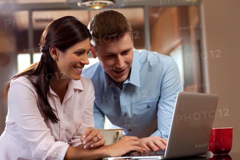 Couple looking at laptop. Photo : db2stock