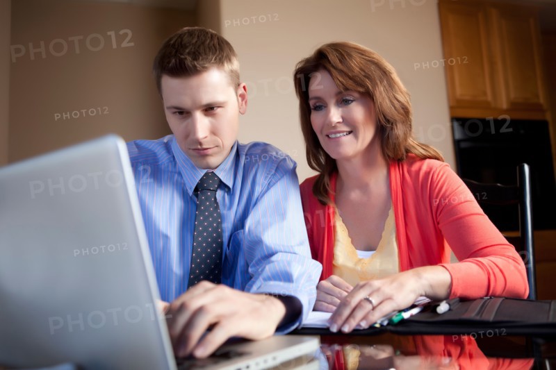 Couple looking at laptop. Photo : db2stock
