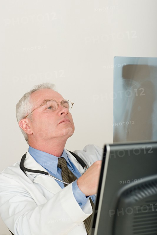 Doctor looking at x-ray image. Photo : Rob Lewine