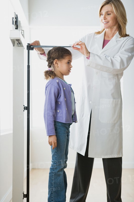 Doctor measuring girl (10-11). Photo : Rob Lewine