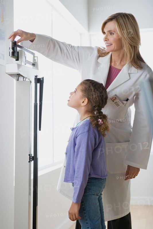 Doctor weighting girl (10-11). Photo : Rob Lewine