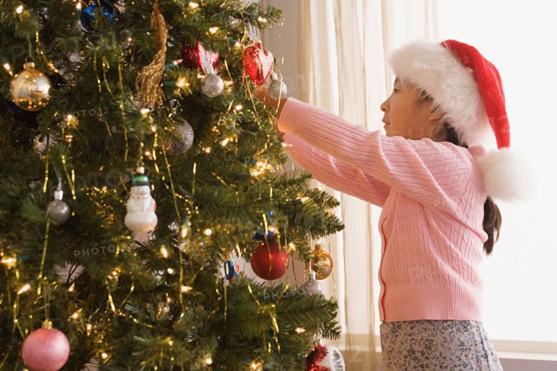 Girl decorating christmas tree. Photo : Rob Lewine