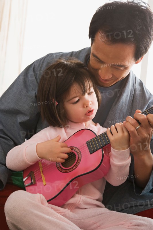 Father and daughter playing guitar. Photo : Rob Lewine