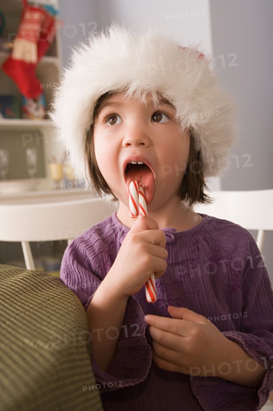 Close-up of girl licking candy cane. Photo : Rob Lewine