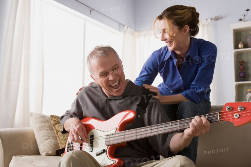 Man playing electric guitar with woman. Photo : Rob Lewine