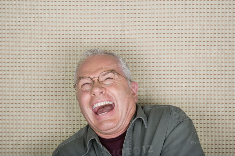 Studio portrait of senior man laughing. Photo : Rob Lewine