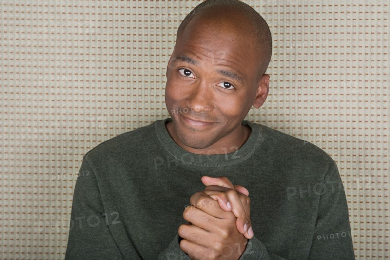 Studio portrait of mid adult man with hands clasped. Photo : Rob Lewine