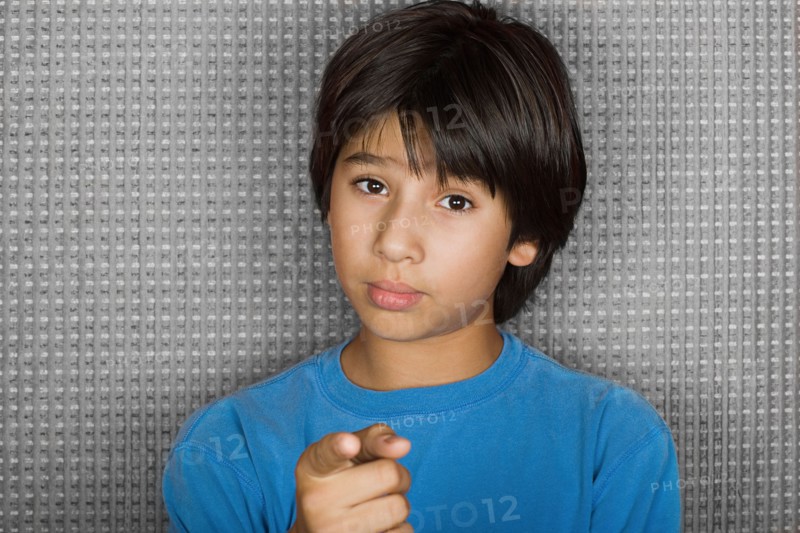 Studio portrait of young man pointing at camera. Photo : Rob Lewine