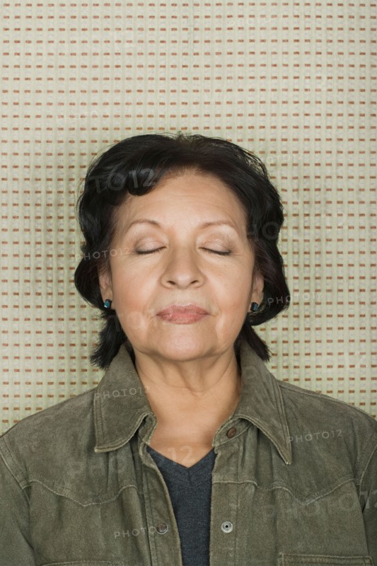 Studio portrait of senior woman with eyes closed. Photo : Rob Lewine