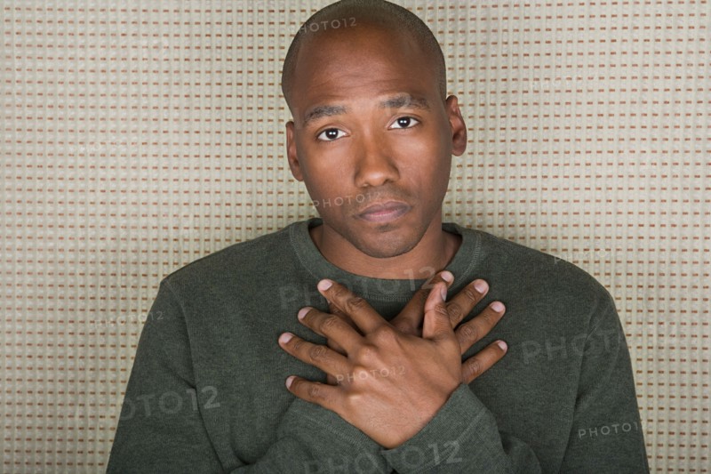 Studio portrait of mid adult man with hands folded on chest. Photo : Rob Lewine