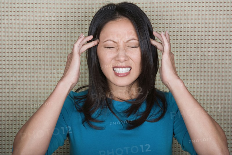 Studio portrait of mid adult woman with head in hands. Photo : Rob Lewine