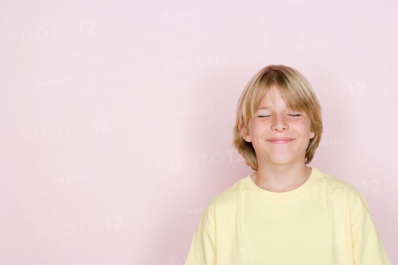 Studio shot portrait of teenage boy with eyes closed, head and shoulders. Photo : Rob Lewine