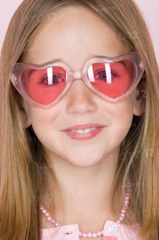 Studio shot portrait of teenage girl in pink sunglasses, close-up. Photo : Rob Lewine