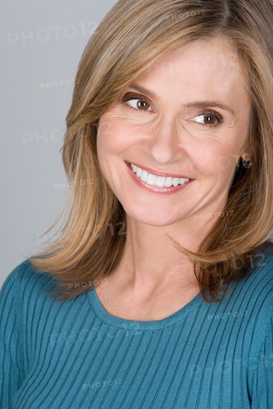 Studio shot portrait of mature woman looking away, head and shoulders. Photo : Rob Lewine
