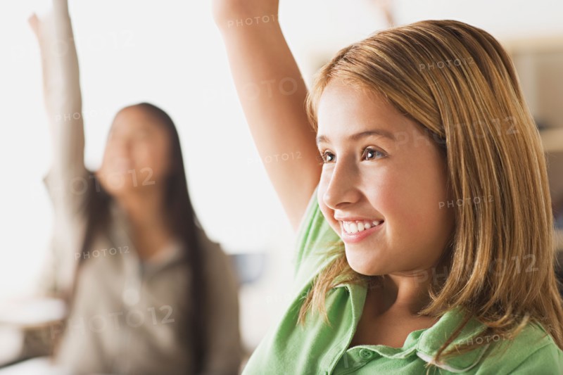 Schoolgirl rising hand in classroom. Photo : Rob Lewine