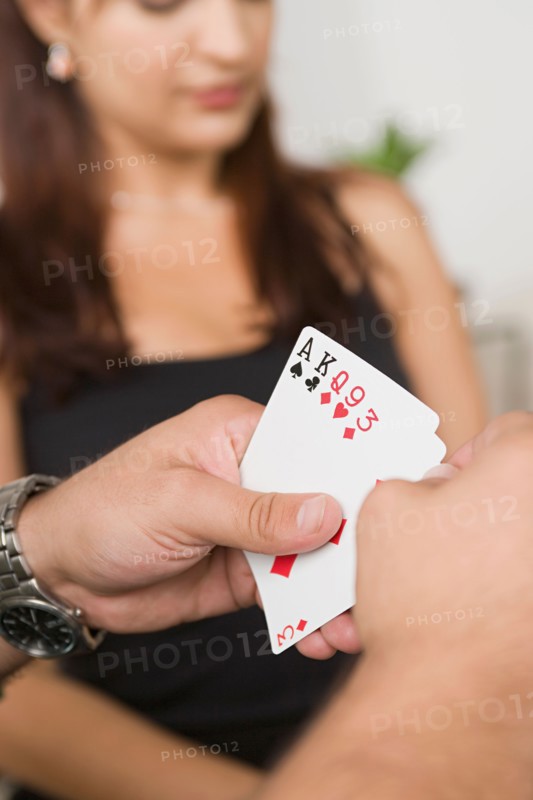 Man's hands holding cards. Photo : Rob Lewine