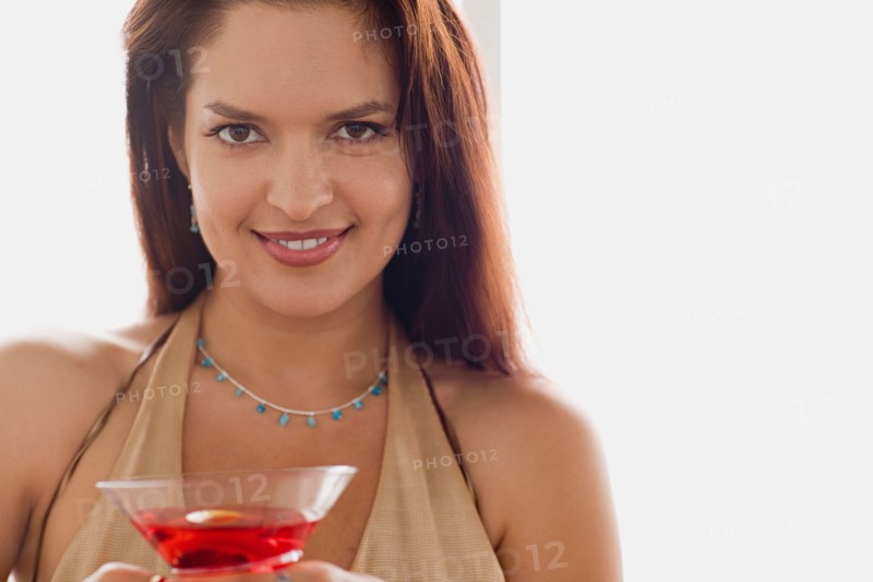 Portrait of smiling mid adult woman holding cocktail. Photo : Rob Lewine