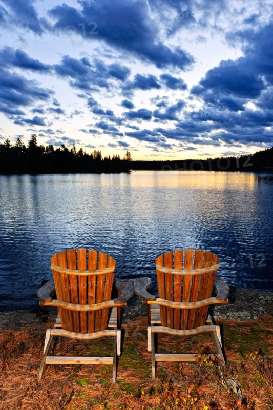 Canada, Ontario, Algonquin Park, Adirondack chairs on edge of lake. Photo :  Elena Elisseeva