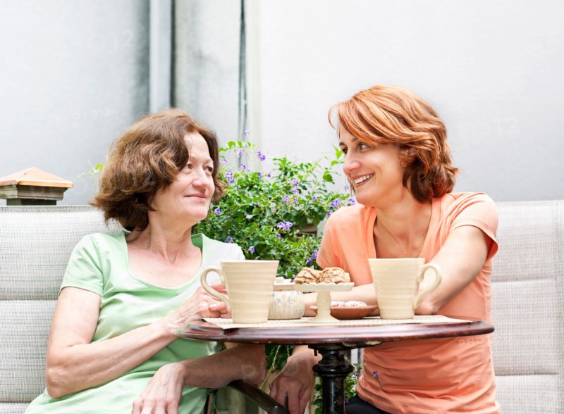 Mother and daughter having coffee in backyard. Photo : Elena Elisseeva