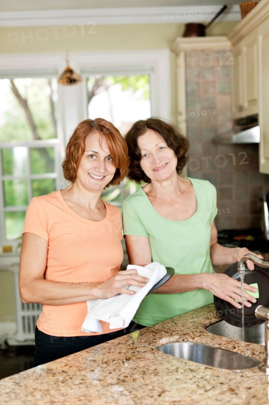 Mother and daughter doing dishes in kitchen. Photo : Elena Elisseeva